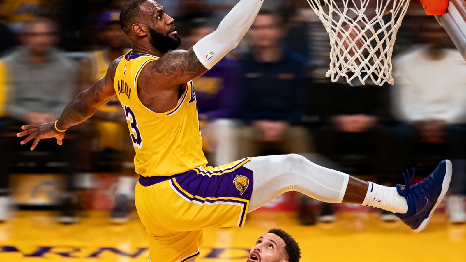 NBA湖人队对阵勇士队的比赛集锦封面，詹姆斯突破扣篮的空中姿态定格，篮筐下的球员仰望这一震撼瞬间